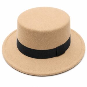 This vintage-inspired flat-top felt boater hat features a structured, cylindrical crown and a flat, circular brim. Colored in a warm camel/tan shade, it is accented with a wide, contrasting black grosgrain ribbon band tied neatly around the base. Crafting a modern, comfortable fit for both men and women, this versatile accessory effortlessly balances casual streetwear aesthetics with formal elegance.Key FeaturesSilhouette: Structural flat-top crown (boater/pork pie hybrid style) paired with a clean, flat wide brim.Material: Lightweight, smooth faux-woolen felt fabric that provides soft warmth during autumn, winter, and spring.Embellishment: Classic black tonal accent ribbon wrapped seamlessly around the lower crown.Sizing: Universal unisex fit, typically featuring an internal circumference of 56–58 cm.Versatility: Complements tailored coats, casual trench jackets, or retro-themed dress ensembles for photography, parties, and everyday wear
